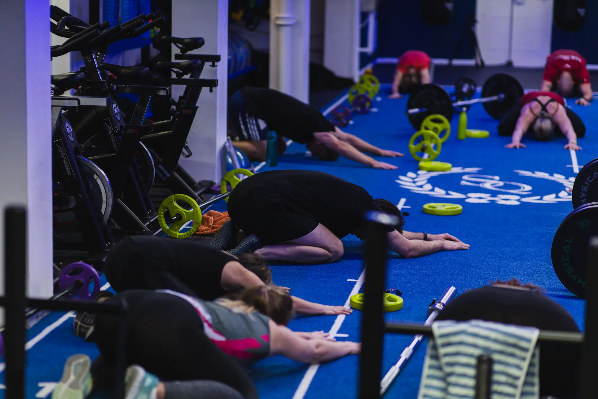 Multiple people stretching in gym